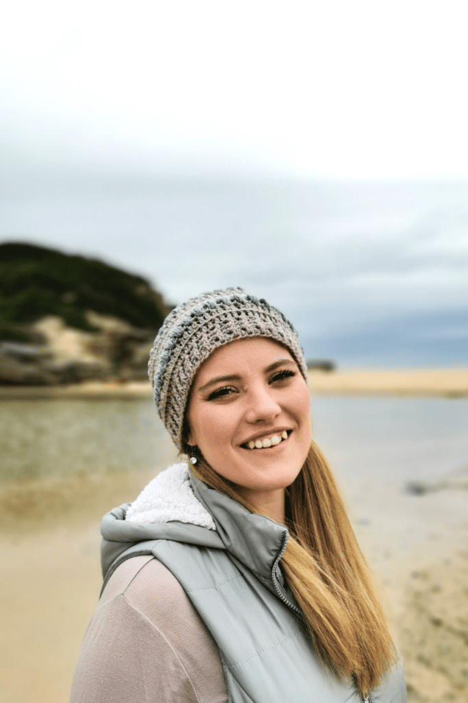 woman smiling and wearing beanie